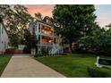 Exterior of home at dusk, featuring double decks, green lawn and mature trees at 891 Paoli Se Ave, Atlanta, GA 30316