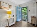 Bright entryway featuring a vibrant blue door, modern decor, hardwood floors, and wainscoting detail at 1410 Cobb Branch Dr, Decatur, GA 30032
