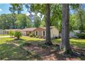 A lush lawn complements this traditional-style home with mature trees at 15 Porter Cir, Hampton, GA 30228