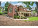 A beautiful backyard showcasing a brick home, lush greenery and a spacious deck at 8250 Saint Marlo Fairway Dr, Duluth, GA 30097