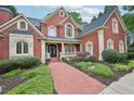 Charming brick home featuring a covered front porch and meticulously maintained landscaping at 8250 Saint Marlo Fairway Dr, Duluth, GA 30097