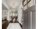Inviting entryway features dark hardwood floors, a light-colored rug and view of the living room at 3317 Sweetleaf Ln, Buford, GA 30519