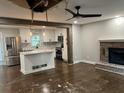 Open concept living room, flowing into a modern kitchen, features hardwood floors and a brick fireplace at 743 San Fernando Se Dr, Smyrna, GA 30080