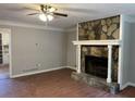 Inviting living room with decorative stone fireplace, ceiling fan and a view to the kitchen at 1978 Winding Creek Sw Ln, Marietta, GA 30064