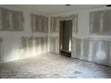 Spacious bedroom features raw wood floors, freshly prepped and primed walls and a doorway leading to another room at 3831 Dillard St, Powder Springs, GA 30127