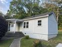 Rear exterior view of the home showing the entrance, light-colored siding, and surrounding yard at 3831 Dillard St, Powder Springs, GA 30127