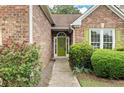 Close-up of the green front door with decorative glass and manicured landscaping at 4801 Devonhurst Way, Powder Springs, GA 30127