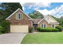 Inviting brick home with green shutters and a lush green lawn at 4801 Devonhurst Way, Powder Springs, GA 30127