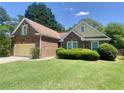 Beautiful brick home showcasing a lush green lawn, mature landscaping, and a welcoming facade at 4801 Devonhurst Way, Powder Springs, GA 30127