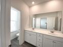 Bathroom with double sinks, a large mirror, and a separate toilet room at 741 Cordele Ln, Sugar Hill, GA 30518