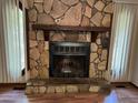 Stone fireplace with wooden mantle, hearth, and metal firebox at 816 Cedar Lake Se Dr, Conyers, GA 30094