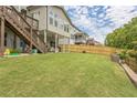 Expansive backyard featuring a lush lawn, a wooden fence, and a covered patio for outdoor enjoyment at 935 Grove Valley Drive Dr, Cumming, GA 30041