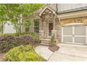 Inviting front entrance with brick accents, a covered porch, and professionally landscaped garden at 935 Grove Valley Drive Dr, Cumming, GA 30041