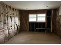Unfinished room with exposed wall studs, insulation, a window, and visible plumbing ready for renovation at 644 Cambridge Dr, Marietta, GA 30066