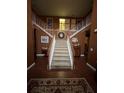 Grand foyer showcasing a staircase with white railings and a decorative rug on the hardwood floor at 311 Arbor Point Sw Ct, Lilburn, GA 30047