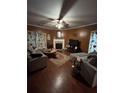 Cozy living room with a fireplace, plush sofas, and dark hardwood floors at 311 Arbor Point Sw Ct, Lilburn, GA 30047