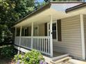 Inviting front porch with white railings and vibrant flowers, creating a warm welcome at 6512 Executive Dr, Winston, GA 30187