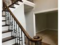 View of the staircase with elegant iron spindles and dark wood treads, leading to the upper level at 730 Redlion Run, Alpharetta, GA 30022