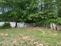 Damaged backyard wooden fence with foliage and mature trees at 1692 Pheasant Dr, Jonesboro, GA 30238