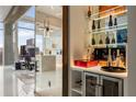 Stylish bar area with glass shelving, wine storage, and views of the modern kitchen and city skyline at 860 Peachtree Ne St # 2801, Atlanta, GA 30308