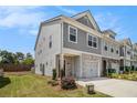 Well-maintained townhome with gray siding, a one-car garage, and a small front yard at 1884 Plainsboro Drive Dr, Lithonia, GA 30058