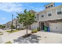 Street view of modern townhomes with gray siding, stone accents, and one-car garages at 1884 Plainsboro Drive Dr, Lithonia, GA 30058