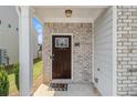 Close-up of the front door, showcasing brick accents, a welcome mat, and a charming entrance at 1884 Plainsboro Drive Dr, Lithonia, GA 30058