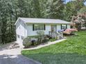 Quaint one-story home with a beautiful yard and driveway leading to a side garage at 301 Jetta Ln, Canton, GA 30115