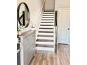 Inviting entryway with hardwood floors, a stylish console table, and stairs leading to the upper level at 6128 Lanier Harbor Lndg, Buford, GA 30518