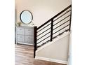 Stylish entryway features sleek, modern railing, hardwood floors, and a decorative storage console at 6128 Lanier Harbor Lndg, Buford, GA 30518