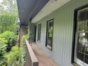 The side of the home features a covered porch, with damaged windows at 7235 Thornhill Ne Ln, Atlanta, GA 30328