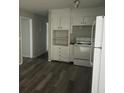 Bright kitchen featuring sleek gray floors, white cabinets and appliances, providing a clean and modern space for cooking and storage at 971 Canyon Sw Trl, Marietta, GA 30060