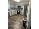 Modern kitchen boasts gray cabinets, stainless steel appliances, and wood-look flooring at 1263 Brookstone Rd, Atlanta, GA 30349