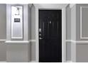 Unit 2304's black door with decorative trim and hallway wall sconce at 1850 Cotillion Dr # 2304, Dunwoody, GA 30338