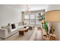 Spacious living room with a large sofa, decorative chandelier, and entertainment center at 1850 Cotillion Dr # 2304, Dunwoody, GA 30338