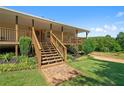 Charming covered porch with wooden railings, stone steps, and lush landscaping create a welcoming entrance at 220 Mountain Creek Rd, Bowdon, GA 30108