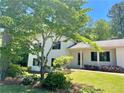 Two-story home with black shutters, a well-manicured lawn, and mature trees at 1028 Gate Post Ln, Lawrenceville, GA 30044