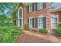 Striking brick home with large windows, black shutters, and meticulous landscaping at 8470 Valemont Dr, Atlanta, GA 30350
