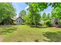 Spacious backyard featuring a large grassy area, mature trees, and partial fencing at 143 Frances Dr, Dallas, GA 30157