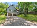 View of the home's exterior with a two-car garage, brick accents, and mature trees at 143 Frances Dr, Dallas, GA 30157