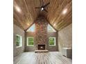 Cozy living room with hardwood floors, exposed brick, a stone fireplace and wood-paneled ceiling at 244 Coastline Road Rd, Fayetteville, GA 30214