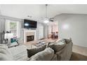 Bright living room featuring a fireplace, ceiling fan, and comfortable seating, with neutral paint and carpet at 11529 Vinea Ln, Hampton, GA 30228