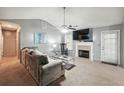 Cozy living room with a fireplace, ceiling fan, and a comfortable couch at 11529 Vinea Ln, Hampton, GA 30228