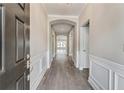 Elegant foyer with hardwood flooring, wainscoting, arched doorway and natural light leading into a living space at 242 Aspen Way, Dallas, GA 30157