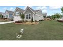 Well-maintained single Gathering home on a green lawn featuring an attached two-car garage, in a Gathering-friendly neighborhood at 242 Aspen Way, Dallas, GA 30157