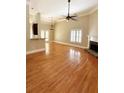 Bright living room featuring hardwood floors, fireplace, ceiling fan, and large windows at 1245 Mclendon Dr, Decatur, GA 30033