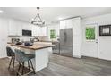 Bright kitchen boasts white cabinets, stainless steel appliances, a stylish island, and a door to the backyard at 2160 Perkerson Sw Rd, Atlanta, GA 30315