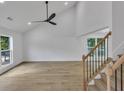 Open living room featuring hardwood floors, a vaulted ceiling, and a modern ceiling fan at 2601 Garland Way, Duluth, GA 30096