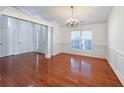 Elegant dining room featuring hardwood floors, wainscoting, a modern chandelier, and abundant natural light at 2642 Colleen Ln, Dacula, GA 30019