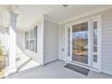 Inviting covered front porch with white columns, neutral siding, and a glass-paneled front door at 2642 Colleen Ln, Dacula, GA 30019